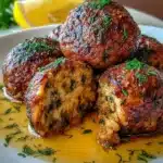 Healthy baked Greek lentil meatballs served on a plate with herbs.