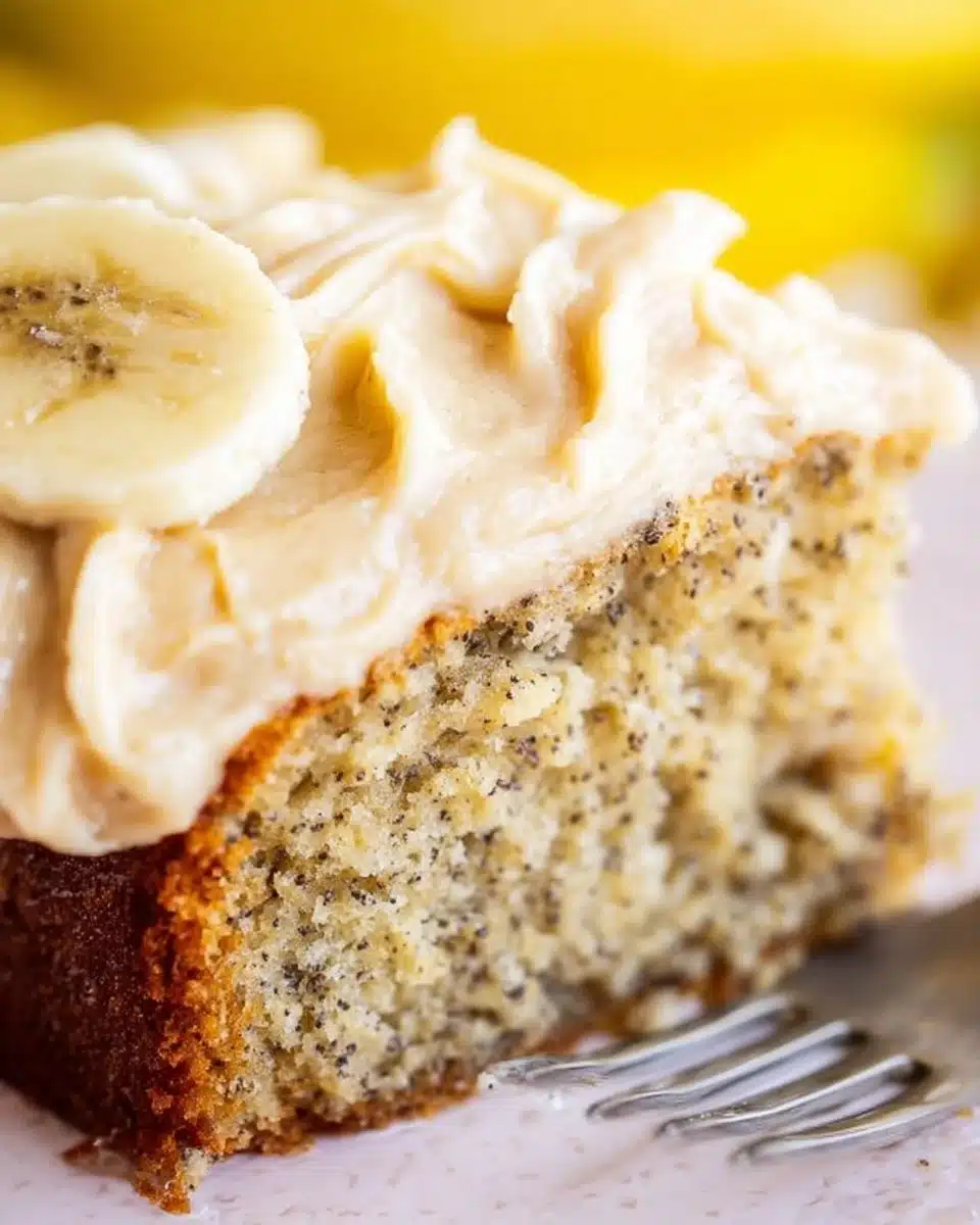 Delicious banana cake topped with spiced vanilla buttercream on a white plate.