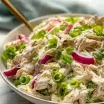 A fresh and colorful chicken salad with vegetables and dressing