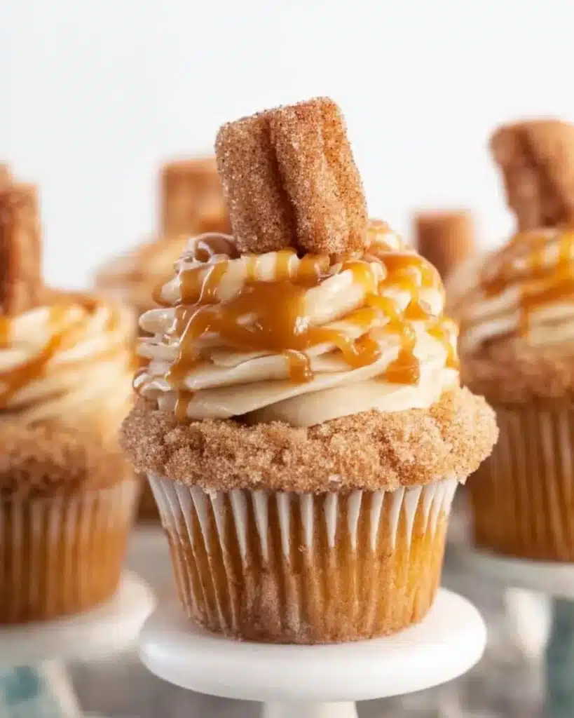 Delicious churro cupcakes topped with cinnamon sugar and creamy frosting.