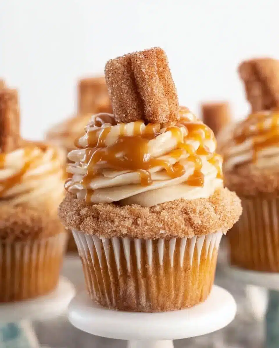 Delicious churro cupcakes topped with cinnamon sugar and creamy frosting.