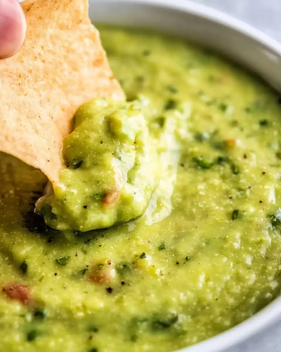 Bowl of vibrant guacamole salsa with fresh ingredients.