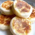 Freshly baked homemade English muffins on a wooden table