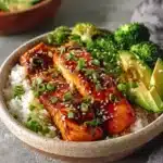 Honey glazed salmon bowl with fresh vegetables and rice