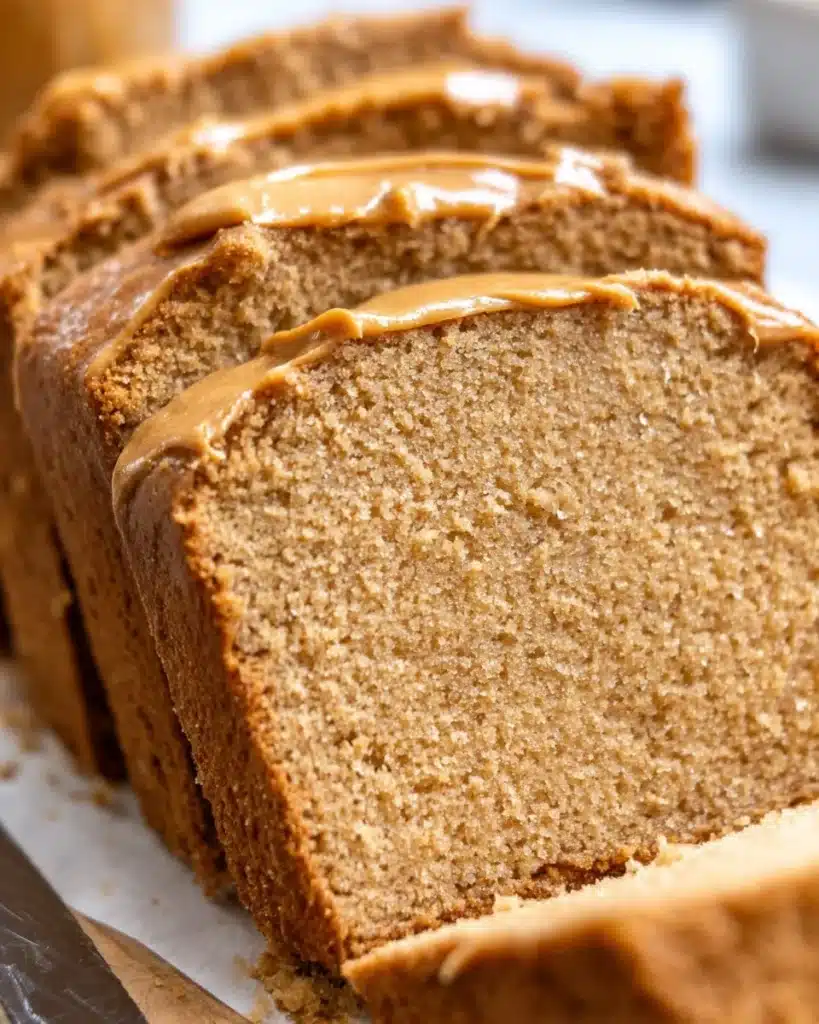 Loaf of freshly baked peanut butter bread sliced on a wooden board