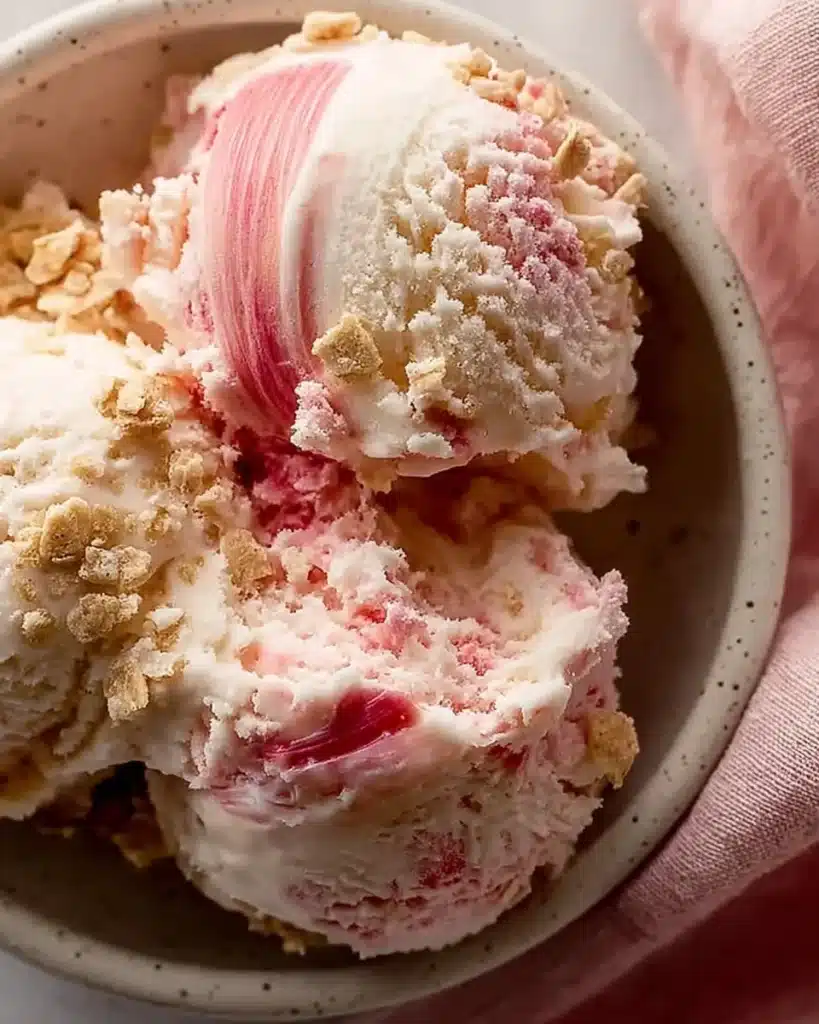 Homemade rhubarb vanilla ice cream served in a bowl with fresh rhubarb