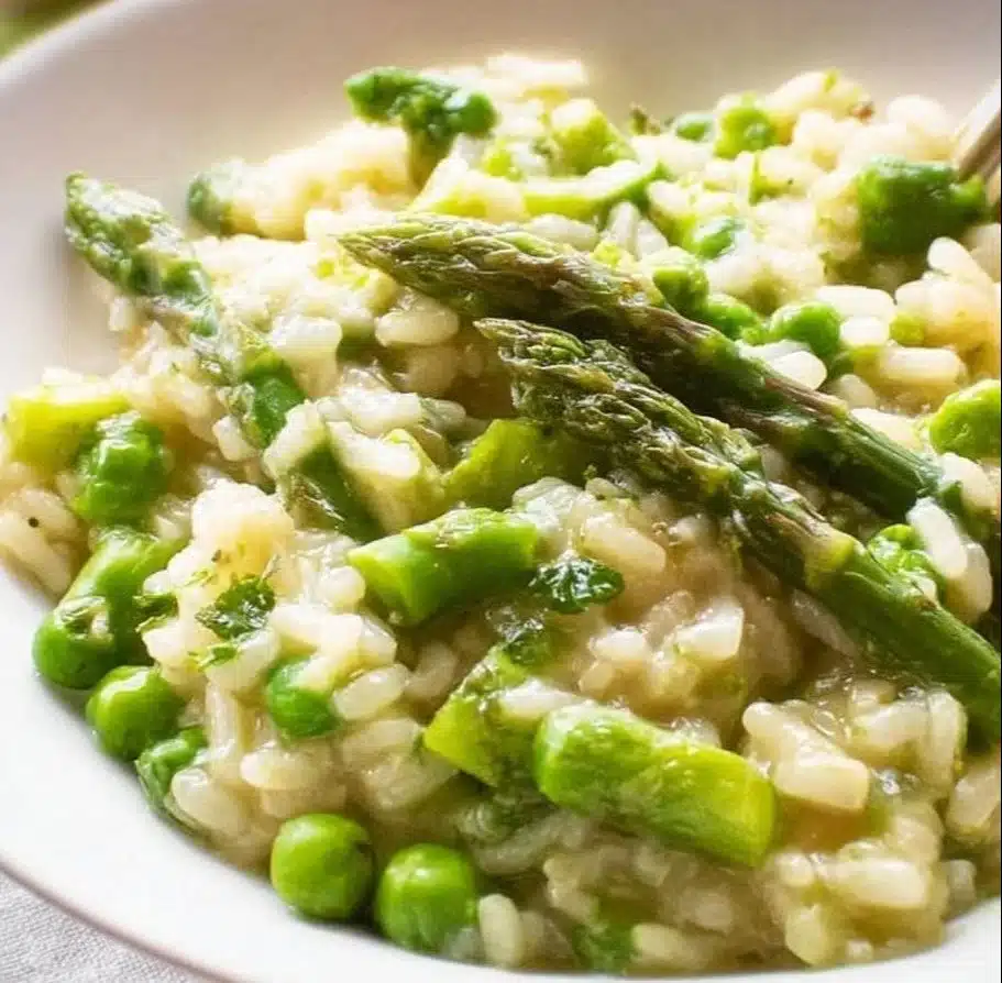 Creamy asparagus pea risotto garnished with fresh herbs