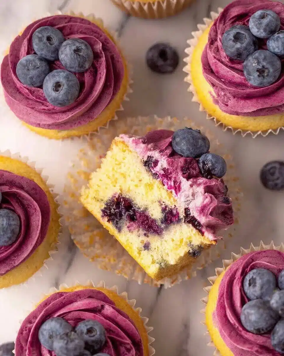 Delicious blueberry lemon cupcakes topped with cream frosting and fresh berries