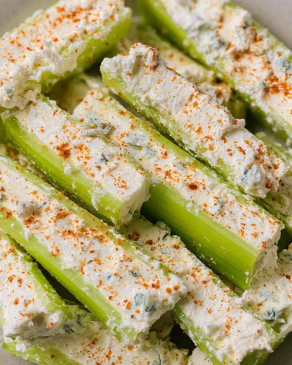 Plate of cheese stuffed celery sticks garnished with herbs.