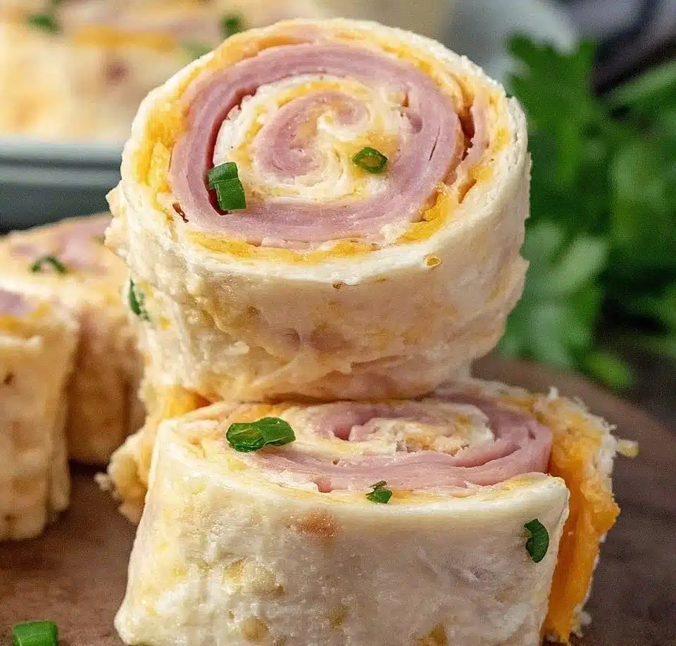 A plate of Ham and Cheese Roll Ups served with dipping sauce