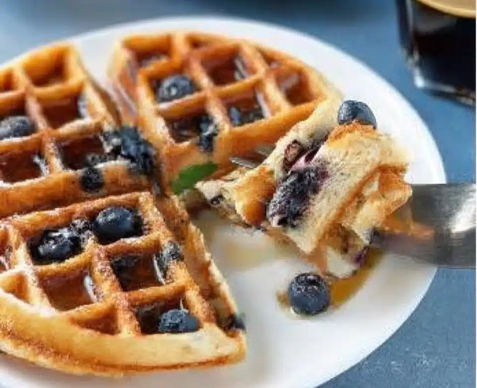 Delicious lemon blueberry waffles topped with fresh blueberries and syrup
