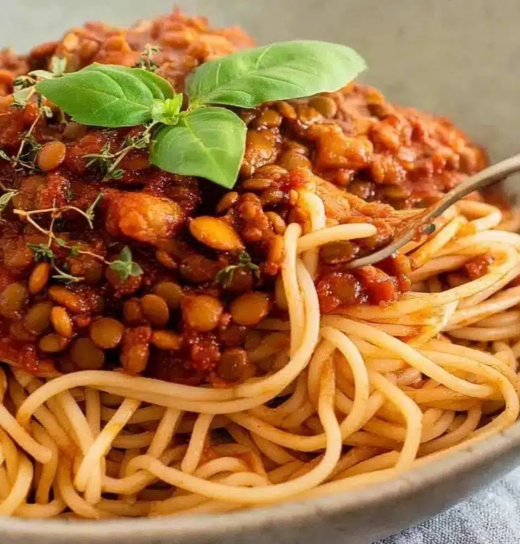 Delicious bowl of Lentil Bolognese served with spaghetti and fresh herbs