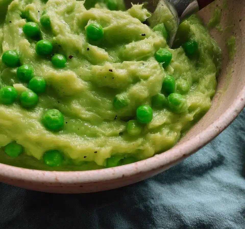 Bowl of perfectly prepared mushy peas with a vibrant green color