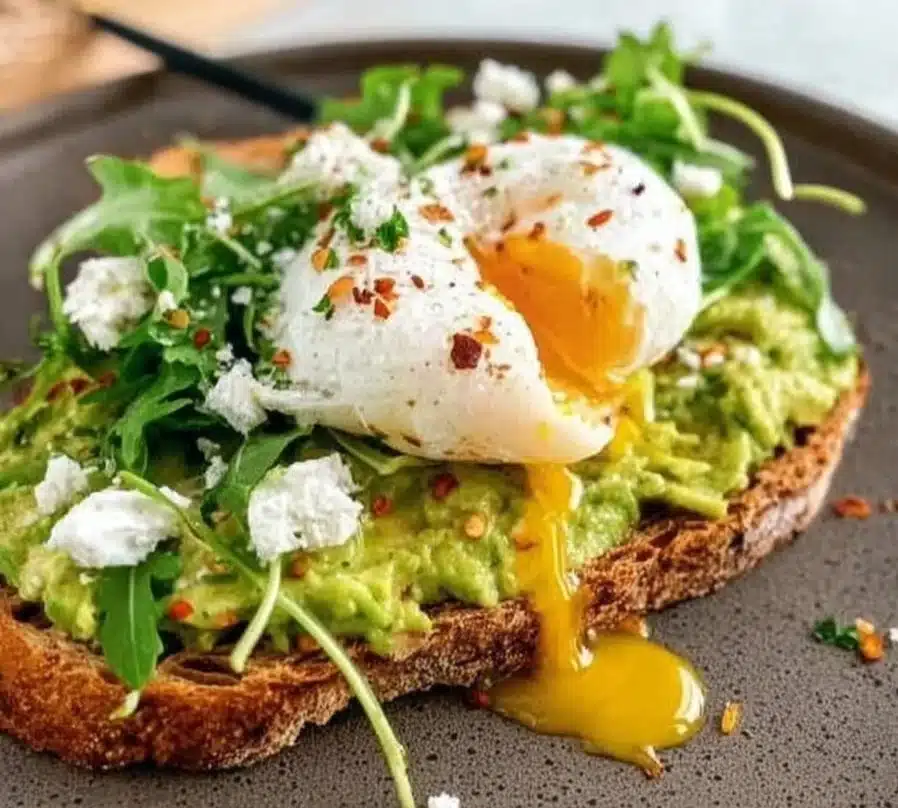 Delicious smashed avocado on toast topped with cherry tomatoes and herbs