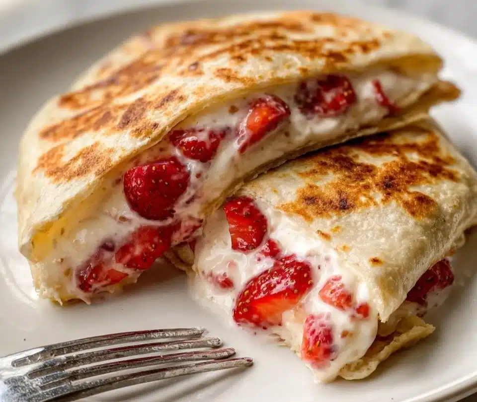 Strawberry Cheesecake Tortilla Rolls served on a plate with fresh strawberries.