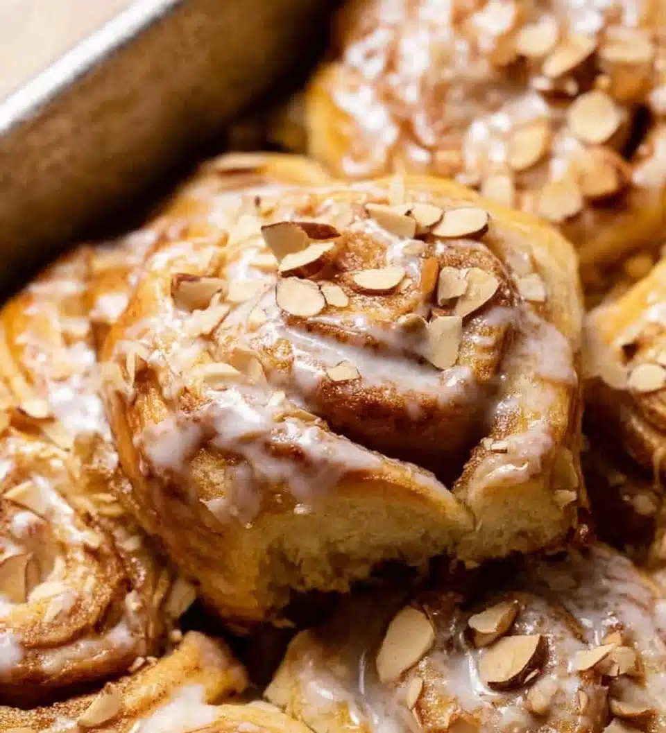 Freshly baked almond croissant cinnamon rolls topped with almond slices