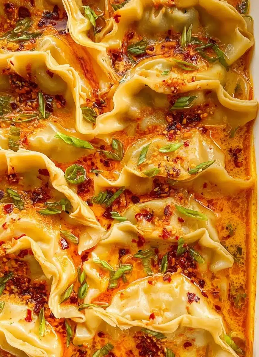 Baked dumpling dish served on a plate, showcasing golden, crispy tops.