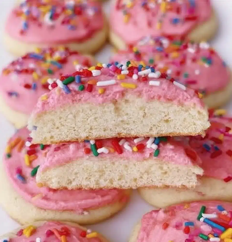 Colorful Lofthouse Cookies topped with frosting and sprinkles on a white background.