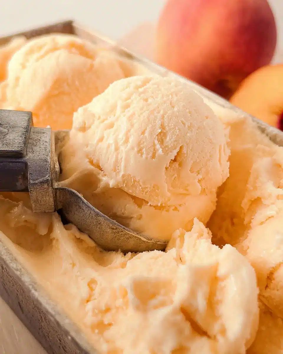Delicious bowl of homemade peach ice cream topped with fresh peach slices