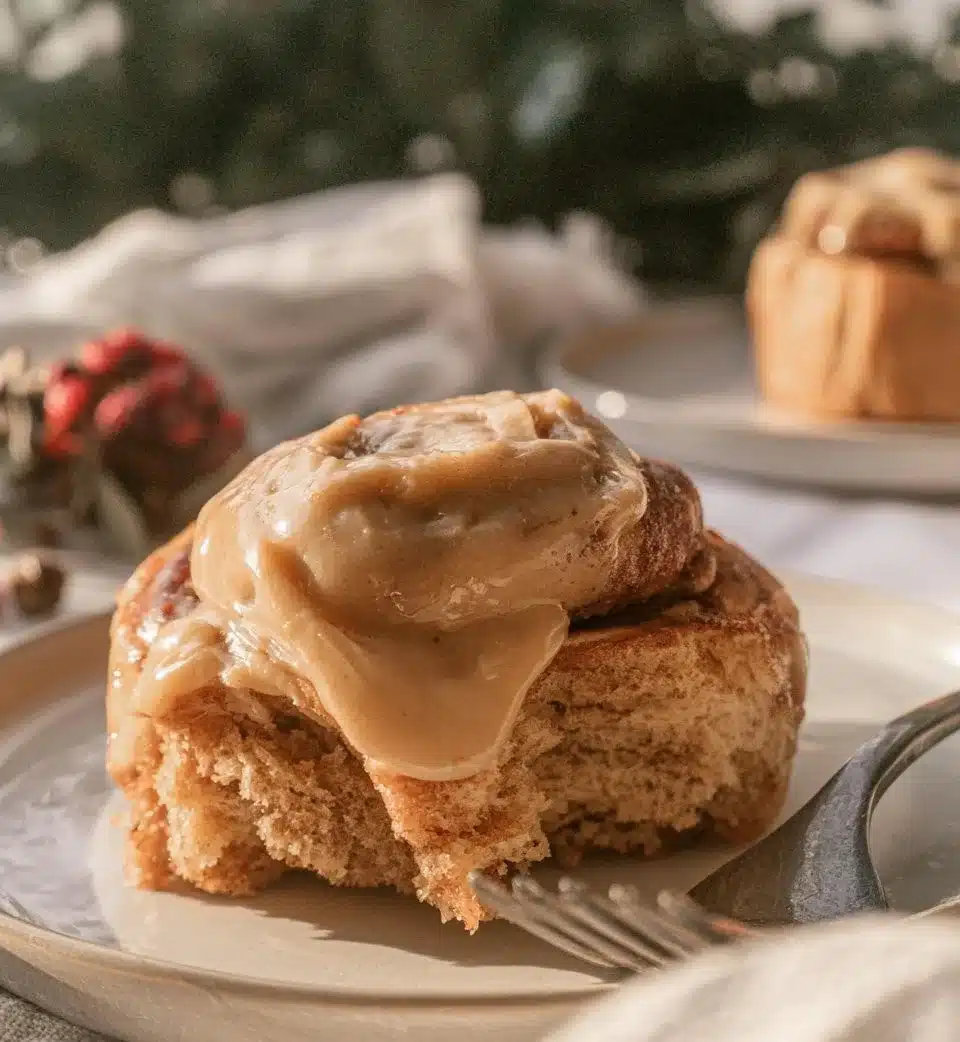 Freshly baked gingerbread cinnamon rolls topped with icing.