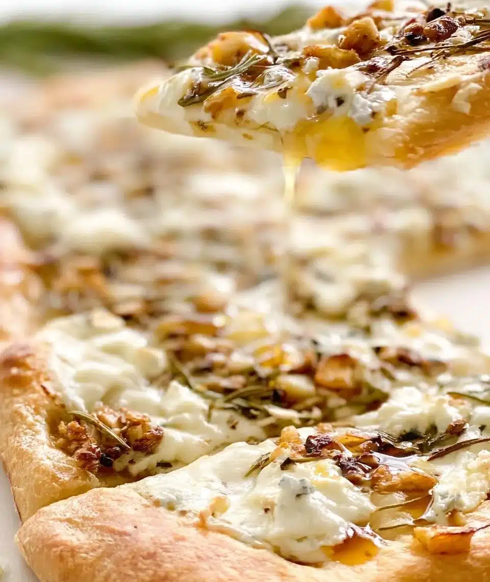 Delicious Honey Goat Cheese Pizza topped with honey and fresh herbs