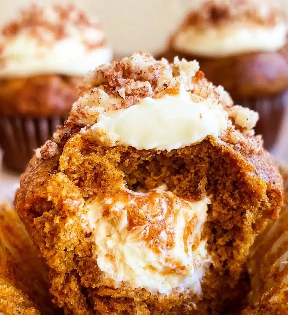 Freshly baked Pumpkin Cream Cheese Muffins on a wooden table