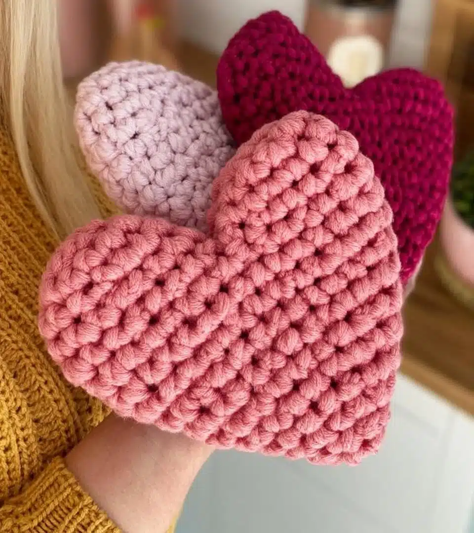 Colorful amigurumi hearts crocheted in various sizes and patterns.