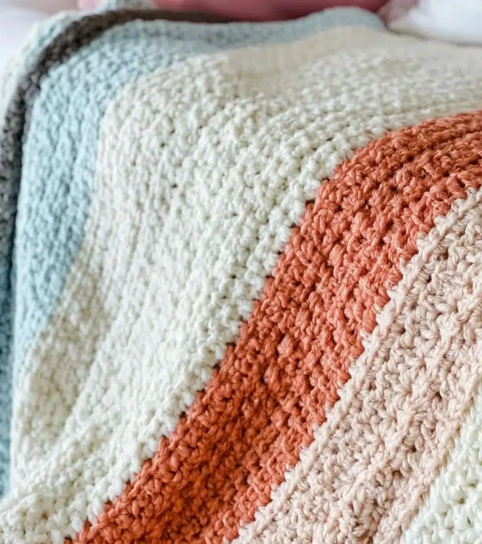 Handmade crochet blanket in soft yarn, perfect for cozy home decor